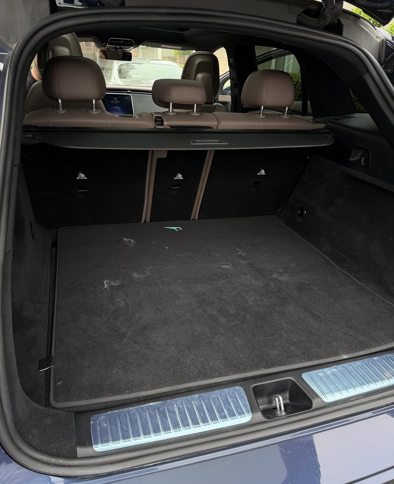 Estate car cargo floor showing lint and pet hair before vacuuming